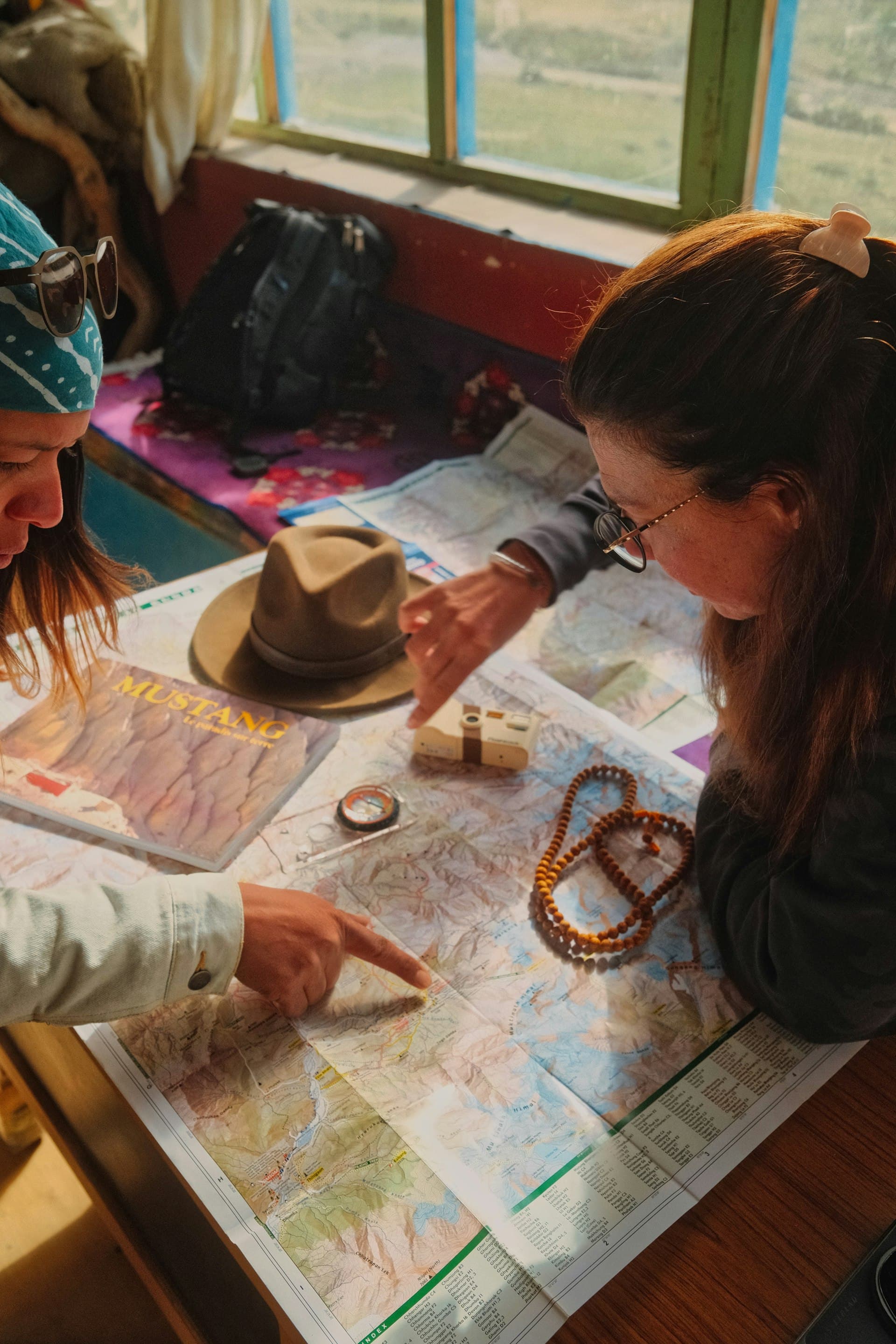 Two travel partners reviewing a route together over a paper map